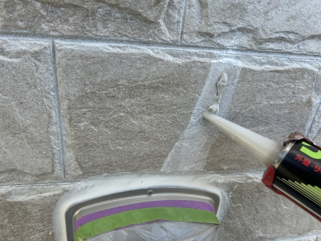 ひび割れ補修材を充填している様子。八潮市S様邸の外壁補修工程