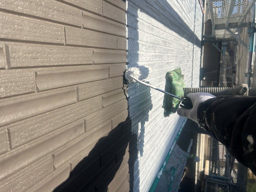 外壁下塗り作業の様子。八潮市S様邸で白系下塗り材を塗布している工程